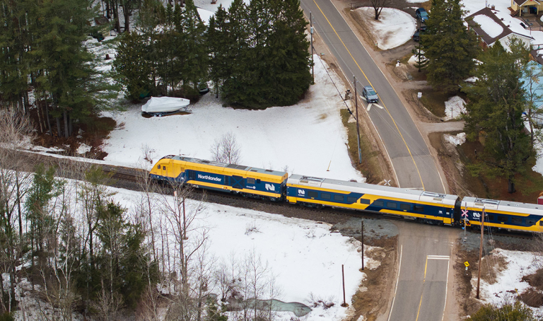 Drone image of Nortlander train passing a rail crossing