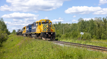 Front view of a train and cars on the tracks